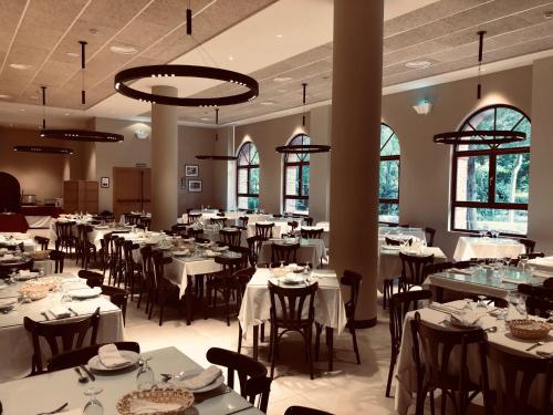 a dining room with white tables and chairs at Hotel Balneario de La Virgen in Jaraba