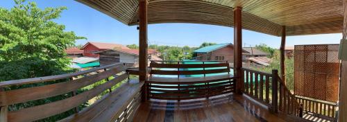 a wooden balcony with a view of a house at Sano Houes in Sukhothai