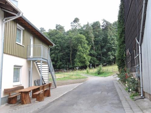 eine Straße mit zwei Bänken neben einem Gebäude in der Unterkunft Ferienwohnungen Zeltnerhof in Breitenbrunn