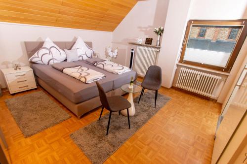 a bedroom with a bed and two chairs and a window at Moselhaus in Zeltingen-Rachtig