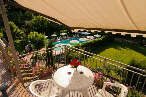 a balcony with a table and chairs and a pool at Casa Vacanze Santa Maria in Montaione