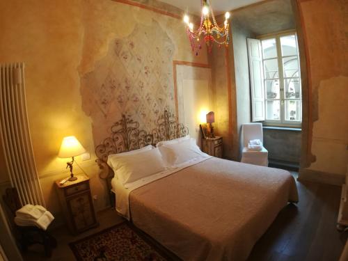 a bedroom with a white bed and a chandelier at Appartamento Signoria in Florence