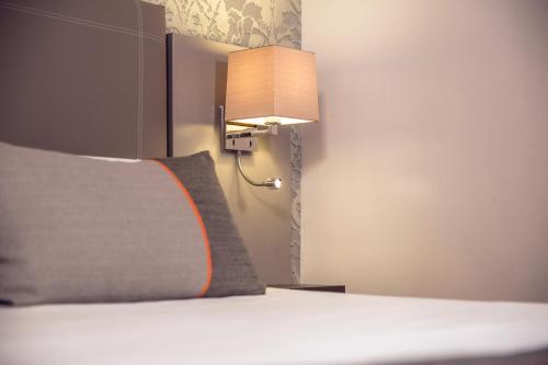 a hotel room with a bed and a lamp at Timhotel Tour Eiffel in Paris