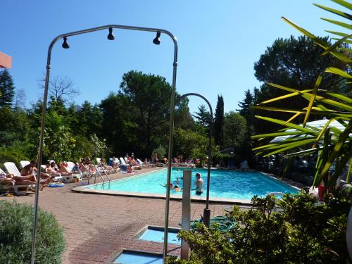 a group of people sitting around a swimming pool at Camping & Resort Valle Romantica in Cannobio
