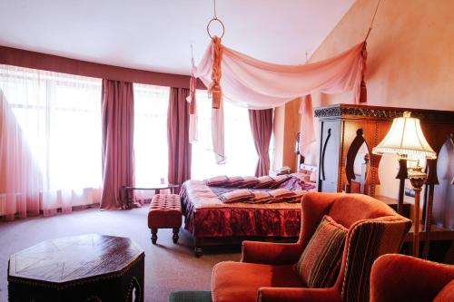 a bedroom with a bed and a chair and a table at Трипільське Сонце in Podgortsy