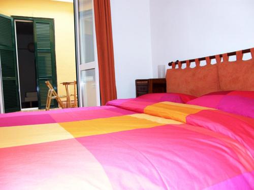 ein Bett mit einer rosa und gelben Decke darauf in der Unterkunft Breakfast In Bed in Rom