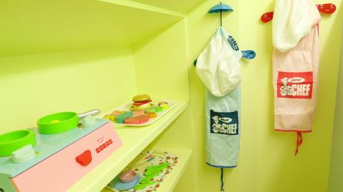 a childs room with a toy kitchen with a shelf at 芹菜芋頭親子民宿 in Taitung City