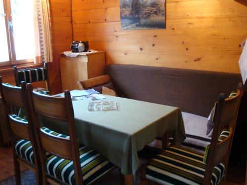 een eetkamer met een tafel en vier stoelen bij Cozy chalet in Bister near ski area in Betten