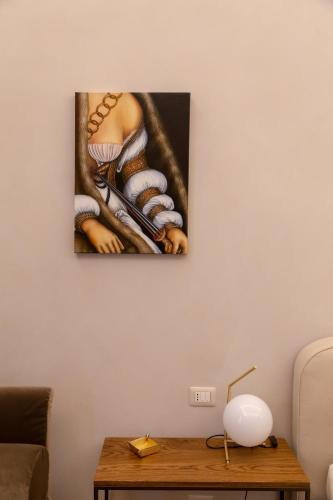 a painting hanging on a wall next to a table at Dimora Storica Lo Svevo in Iesi