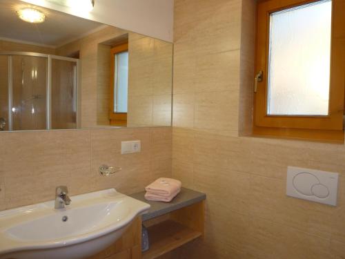 a bathroom with a sink and a mirror at Residence Ferienheim Folie in Melago