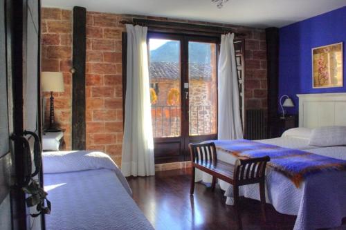 a bedroom with two beds and a window at La Casona del Pastor in Valgañón