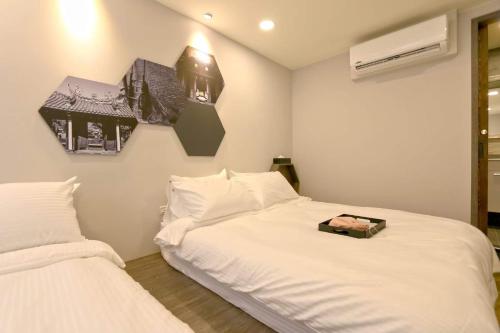 a bedroom with two beds with white sheets at Lukang Barn Inn in Lugang