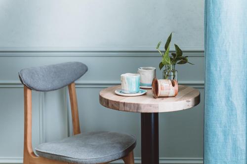 a table with a chair and a table with a cup and aucer at HOY Paris - Yoga Hotel in Paris