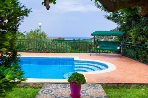 a swimming pool in a yard with a fence at Villa Apelia - Family Holidays Deals in Vlikhádha