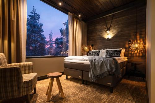 a bedroom with a bed and a large window at Lapland Hotels Sky Ounasvaara in Rovaniemi