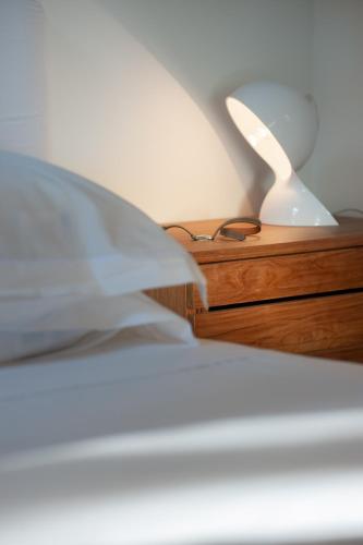 a bed with a night stand with a lamp and glasses at Maison Dauphine in Aix-en-Provence