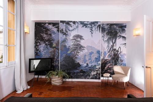 a living room with a large painting on the wall at Maison Dauphine in Aix-en-Provence