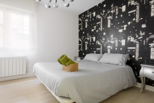 Schlafzimmer mit einem Bett mit einer schwarz-weißen Wand in der Unterkunft Confortable piso en el Puerto Viejo de Algorta, a 7 min de la playa in Getxo