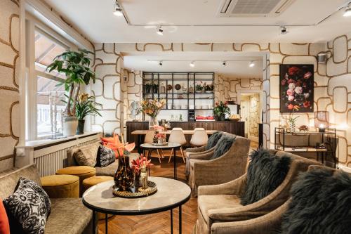 a living room with couches and tables in a room at The Delphi - Amsterdam Townhouse in Amsterdam