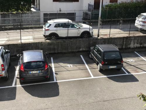 a couple of cars parked in a parking lot at Appartamento Lake Como in Gravedona