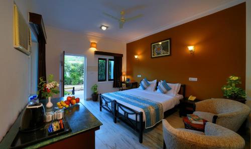 Habitación de hotel con cama, mesa y sillas en TreeHouse The Pugmark, A Wildlife Resort, en Sawāi Mādhopur