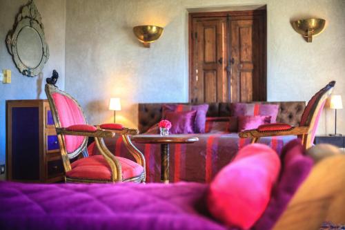 a living room with a couch and chairs and a table at Kasbah Tabelkoukt in Mirleft