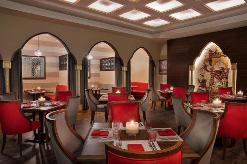 a restaurant with tables and chairs in a room at voco Al Khobar by IHG in Al Khobar
