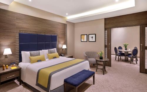 a hotel room with a large bed and a desk at voco Al Khobar by IHG in Al Khobar