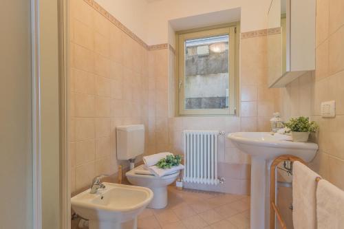 a bathroom with a sink and a toilet and a window at Palma Romantic Dream in Perledo