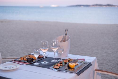 a table with wine glasses and a tray of food at DS One Vacances, Prairies de la Mer in Grimaud
