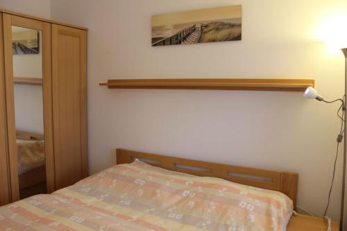 a bedroom with a bed and a shelf on the wall at Apartmán Lipánek in Lipno nad Vltavou