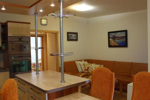 a kitchen and living room with a table and a couch at Apartmán Lipánek in Lipno nad Vltavou