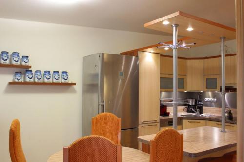 eine Küche mit einem Tisch und einem Kühlschrank aus Edelstahl in der Unterkunft Apartmán Lipánek in Lipno nad Vltavou