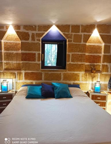 a bedroom with a large bed with blue pillows at VILLE GIRASOLI "VILLA NELLA BAIA" with PRIVATE SWIMMING POOL in Tricase