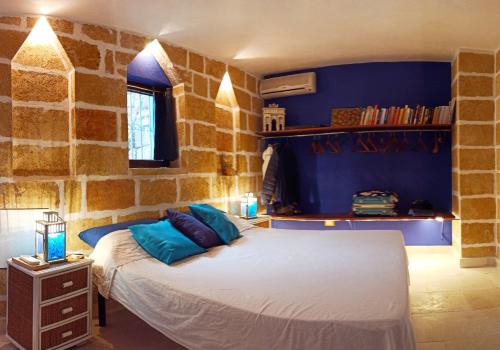 a bedroom with a bed in a stone wall at VILLE GIRASOLI "VILLA NELLA BAIA" with PRIVATE SWIMMING POOL in Tricase
