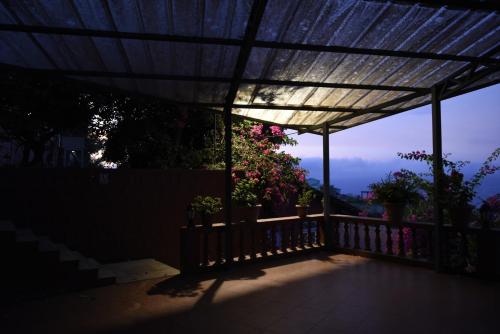 a pergola with potted plants on a balcony at Brightland Resort & Spa in Mahabaleshwar