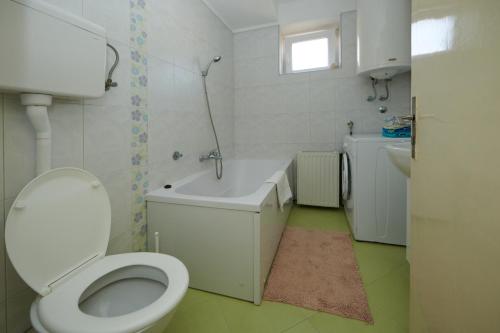 a bathroom with a toilet and a tub and a sink at Apartman Pero in Kikinda