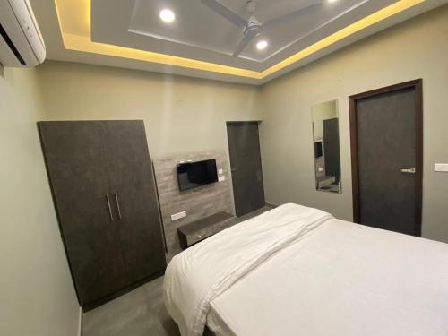 ein Schlafzimmer mit einem Bett und einem Fernseher an der Wand in der Unterkunft Hotel The Retro Regency in Ludhiana