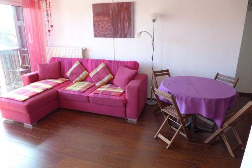 a living room with a pink couch and a table at Réf 475, Seignosse océan, appartement proche plage et commerces, 4 personnes in Seignosse