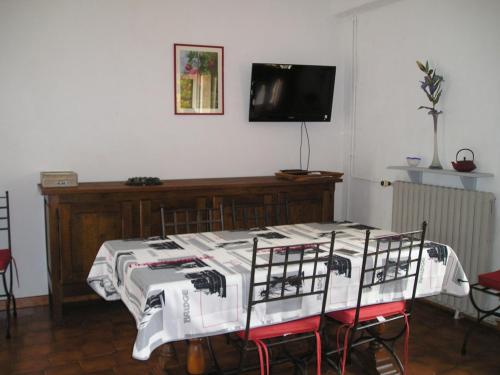 een kamer met een tafel met stoelen en een televisie bij GITE MAMIE LAURENCE in Gruissan