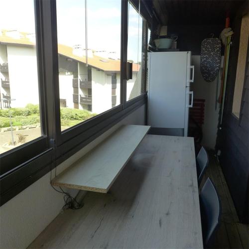 - un banc dans une chambre avec une fenêtre et un réfrigérateur dans l'établissement Réf 539, Seignosse Océan, Appartement à 150m de la plage, proche commerces, 4 personnes, à Seignosse