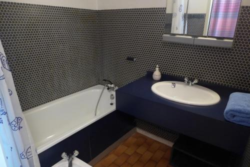 une salle de bain avec un lavabo et une baignoire dans l'établissement Réf 271, Seignosse Océan, Villa Patio au calme sous les pins, à quelques minutes de la plage et des commerces, 5 personnes, à Seignosse