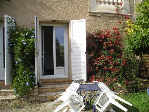 two white chairs and a table in front of a house at GITE MAMIE LAURENCE in Gruissan