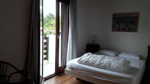 a bedroom with a bed and a door to a balcony at Réf 259, Seignosse océan, Villa Patio au calme, plage et commerces à proximité, 6 personnes in Seignosse
