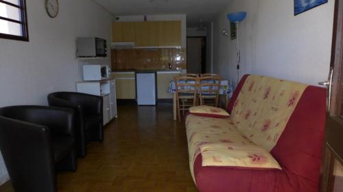 a living room with a couch and a kitchen at Réf 434 Seignosse océan, appartement classé 2 étoiles, accès direct à l'océan et place de parking privée, 4 personnes in Seignosse