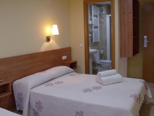 1 dormitorio con 2 camas y toallas. en Hostal Sant Sadurní, en Sant Sadurní dʼAnoia