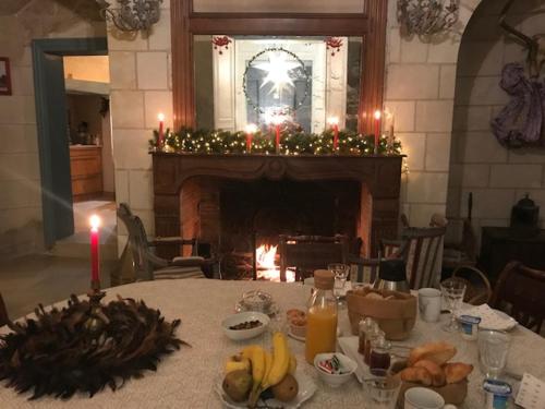 een tafel met een kaars en een open haard in een kamer bij Le Grand Vaudon in Rochecorbon