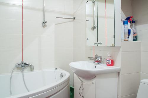 biała łazienka z umywalką i wanną w obiekcie Like at Home w Lwowie