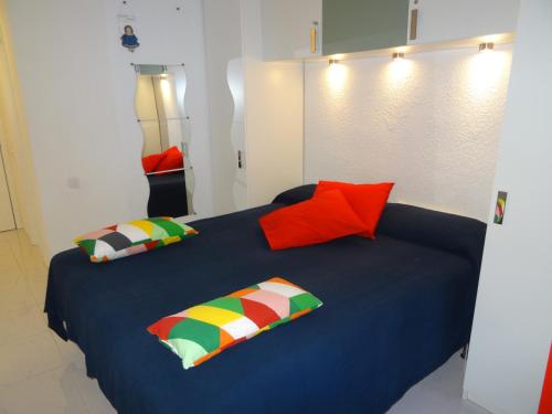 a bedroom with a blue bed with colorful pillows at Ocean View in Adeje