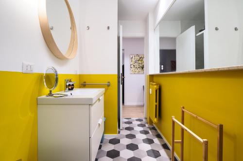 a yellow bathroom with a sink and a mirror at PrimoPiano - Fargorida in Milan